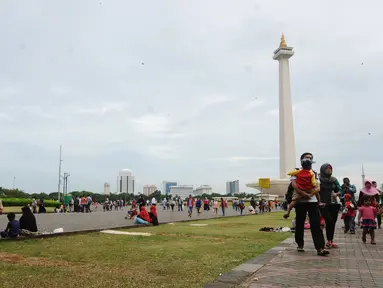 Warga berjalan-jalan di kawasan Monumen Nasional, Jakarta, Minggu (25/12). Libur perayaan Natal 2016 dimanfaatkan sejumlah warga untuk berwisata di kawasan Monumen Nasional. (Liputan6.com/Helmi Fithriansyah)