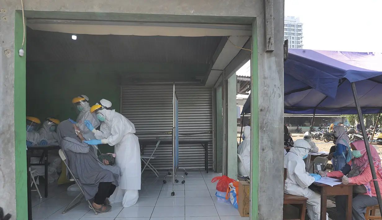 Petugas medis dari Pemkot Jakarta Selatan melakukan tes swab Covid-19 para pedagang  di Pasar Sayur Cipulir, Jakarta Selatan, Kamis (25/6/2020). Kegiatan yang dilakukan kepada puluhan pedagang dan warga seputar pasar ini dalam rangka memutus mata rantai penyebaran Covid-19. (merdeka.com/Arie Basuki)