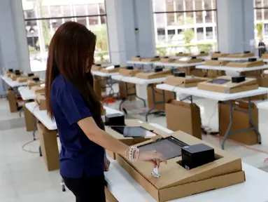 Petugas komisi pemilihan menjelaskan bagaimana menggunakan komputer selama pemungutan suara digital di sebuah TPS di Panama City, Panama (3/5/2019). Pemungutan suara di pemilu Panama telah menggunakan teknologi digital berbasis komputer. (Reuters/Carlos Jasso)