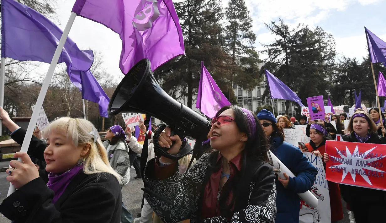 Para perempuan berbaris dengan membawa bendera dan plakat dalam sebuah unjuk rasa untuk memperingati Hari Perempuan Internasional di Bishkek pada 8 Maret 2025. (VYACHESLAV OSELEDKO/AFP)