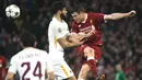 Pemain Liverpool, James Milner menyundul bola dibayangi pemain AS Roma pada laga leg pertama semifinal Liga Champions 2017-2018 di Anfield, Selasa (24/4). Liverpool mengalahkan AS Roma di kandang sendiri dengan skor 5-2.  (Filippo MONTEFORTE/AFP)