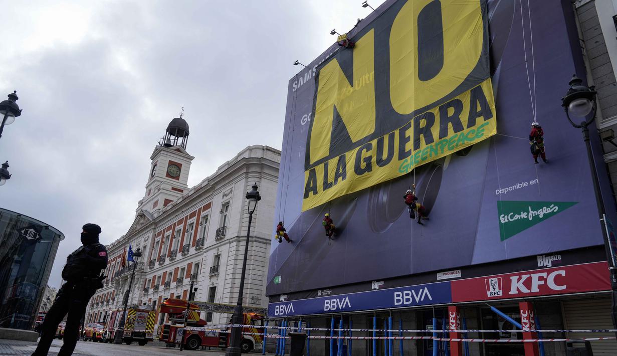 Di salah satu bangunan Lapangan Puerta del Sol, Madrid, Spanyol, pada Selasa 10 Maret 2026, sejumlah aktivis Greenpeace membentangkan spanduk besar bertuliskan "Tidak untuk Perang". Tampak dalam foto, petugas polisi membentuk perimeter saat aktivis Greenpeace membentangkan spanduk besar bertuliskan "Tidak untuk Perang" sebagai bentuk protes terhadap serangan Amerika Serikat (AS) dan Israel terhadap Iran, di Lapangan Puerta del Sol, Madrid, Spanyol, pada Selasa 10 Maret 2026. (Paul Hanna/AFP)