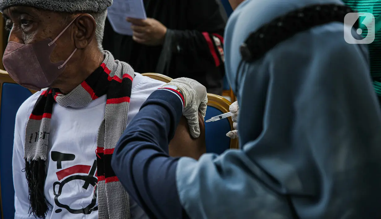 Petugas kesehatan menyuntikkan vaksin COVID-19 booster kepada warga saat kegiatan Car Free Day (CFD) di kawasan Bundaran HI, Jakarta, Minggu (17/12/2023). (Liputan6.com/Faizal Fanani)