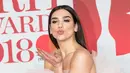 Penyanyi cantik Dua Lipa berpose untuk fotografer setibanya di karpet merah Brit Awards 2018 di O2 Arena, London, Rabu (21/2). Penyanyi 22 tahun ini tampil memesona dengan gaun tile berdetail layering warna pink pastel. (Vianney Le Caer/Invision/AP)