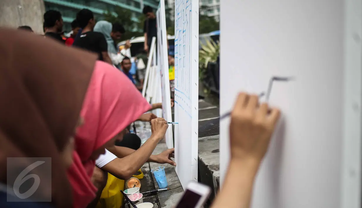 Pengunjung mengikuti aksi melukis di kanvas disela kegiatan Car free Day (CFD) di kawasan Bundaran HI, Jakarta, Minggu (12/2). Aksi yang digelar oleh Greenpeace itu untuk mengenalkan masyarakat tentang sadar polusi. (Liputan6.com/Faizal Fanani)
