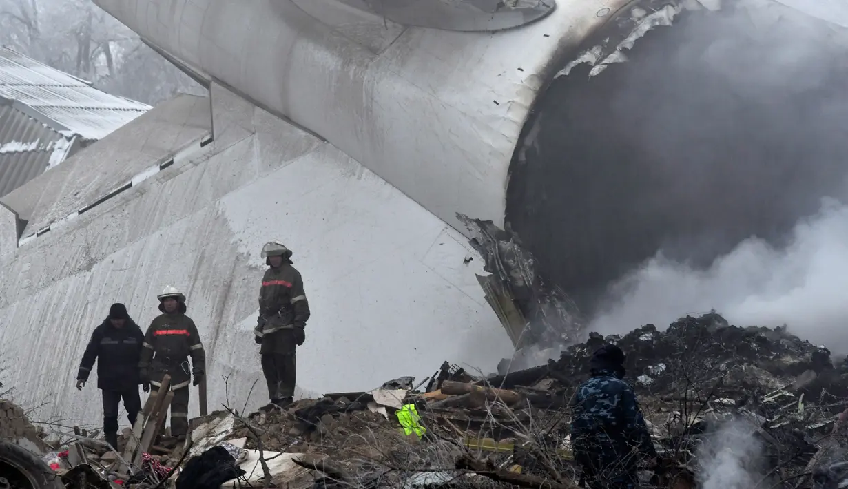 Petugas mengevakuasi bangkai pesawat kargo Turki yang jatuh di daerah perumahan di Bishkek, Kyrgyzstan (16/1). Sebuah pesawat kargo milik Turkish Airlines jatuh dekat Bandara Manas, Kyrgyztan. (AP Photo/Vladimir Voronin)