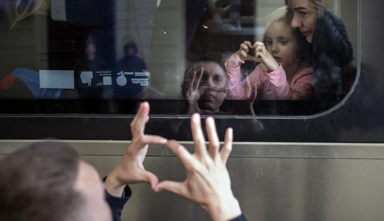 Nicolai (41) dari Ukraina mengucapkan selamat tinggal kepada putrinya Elina (4) dan istrinya Lolita yang berada dalam kereta menuju Polandia untuk melarikan diri dari perang di stasiun kereta di Lviv, Ukraina, 15 April 2022. Serangan Rusia ke Ukraina memasuki hari ke-51. (AP Photo/ Emilio Morenatti)