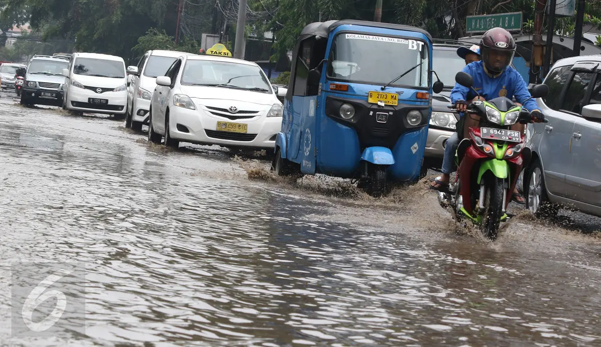 Sejumlah kendaraan mencoba menerobos genangan air di Jalan Cikini Raya, Jakarta, Sabtu (7/11). Meski baru pertama kali diguyur hujan selama musim kemarau, jalan tersebut langsung terendam air. (Liputan6.com/ Immanuel Antonius)