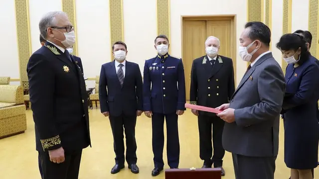 Duta Besar Rusia di Korea Utara, Alexander Matsegora, menyerahkan medali dari Vladimir Putin untuk Kim Jong-un kepada Menteri Luar Negeri Korea Utara Ri Son-gwon. (AP)