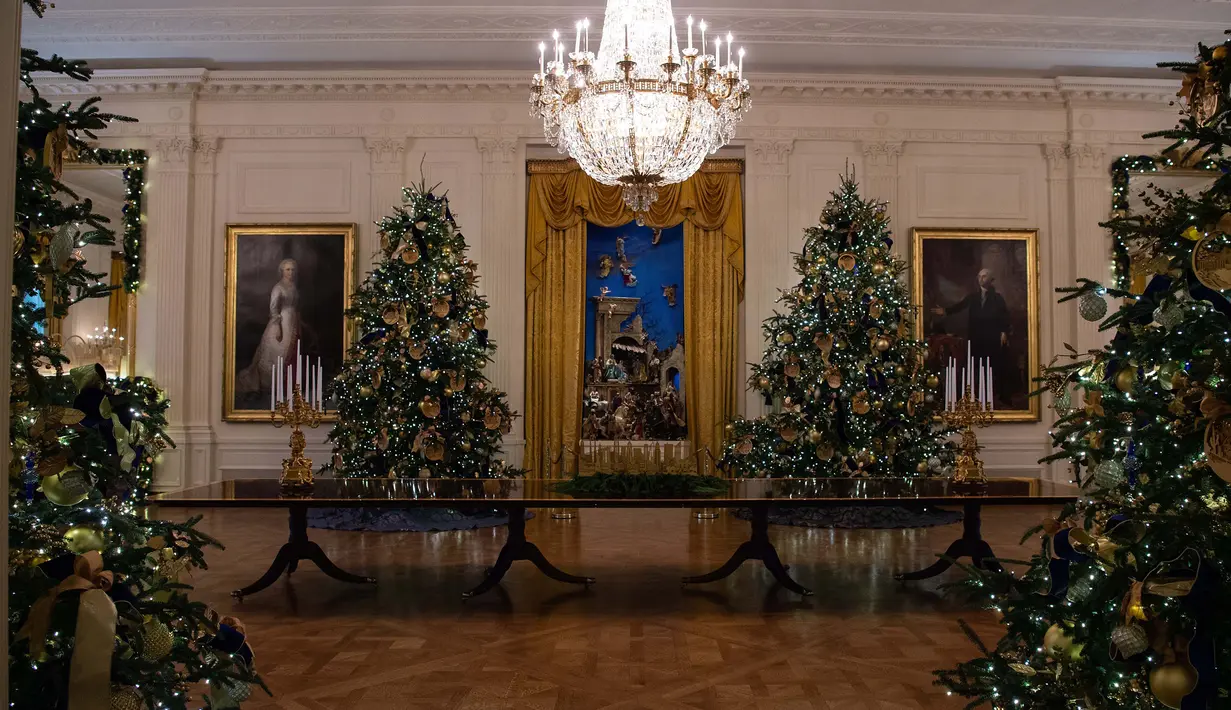 Sejumlah pohon cemara yang didekorasi untuk perayaan Natal terlihat selama pratinjau dekorasi liburan 2018 di Gedung Putih, Washington DC, Senin (26/11). Tema dekorasi yang diangkat tahun 2018 ini adalah 'American Treasures'. (NICHOLAS KAMM / AFP)