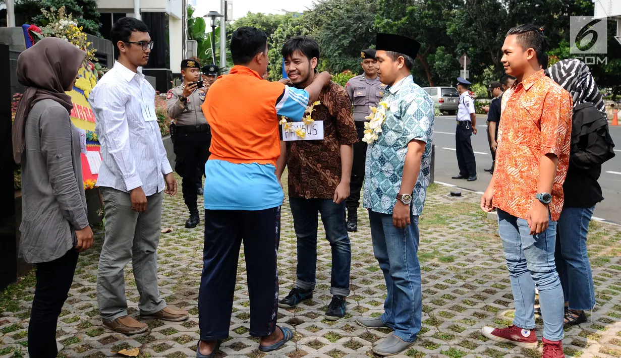 Aktivis berperan sebagai narapidana kasus korupsi menyambut anggota Pansus Hak Angket KPK dalam adegan parodi di depan Gedung KPK, Jakarta, Minggu (9/7). Mereka mengkritisi pertemuan tersebut. (Liputan6.com/Helmi Fithriansyah)