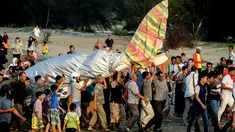 Sejumlah warga mengevakuasi pesawat Shark Aero PK S 121 yang dipiloti gubernur Aceh, Irwandi Yusuf seusai mendarat darurat di kawasan Ujong Pancu, Aceh Besar, Sabtu ( 17/2). Irwandi mendaratkan darurat pesawatnya di tepi pantai. (CHAIDEER MAHYUDDIN/AFP)