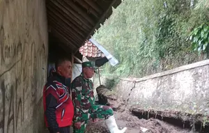 Hantaman material longsor menyebabkan Tembok Penahan Tanah (TPT) sepanjang 20 meter dengan tinggi 2 meter di Kampung Cigadog, Desa Padamukti. Camat Pasirwangi ambruk. (Liputan6.com/Jayadi Supriadin)