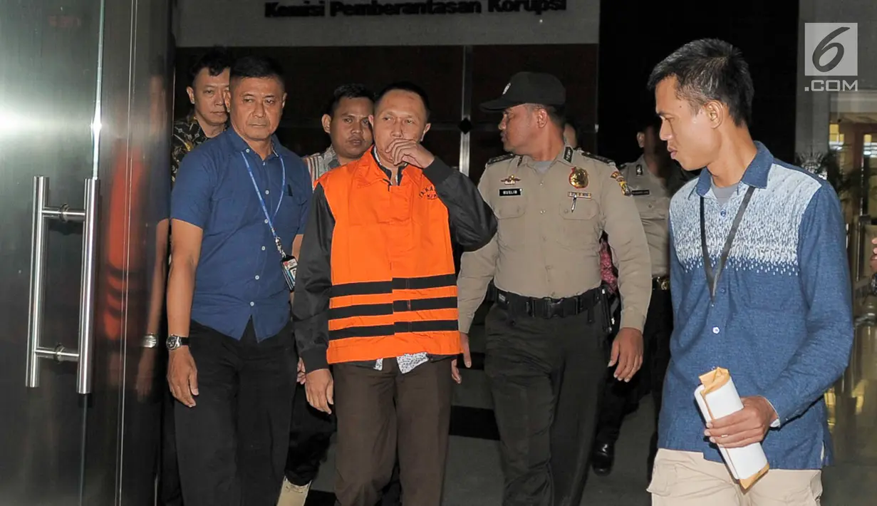 Kajari Pamekasan Rudi Indra Prasetya dikawal petugas KPK usai menjalani pemeriksaan di gedung KPK, Jakarta, Kamis (3/8). Dari ke-11 yang tertangkap KPK menetapkan lima di antaranya sebagai tersangka. (Liputan6.com/Yoppy Renato)