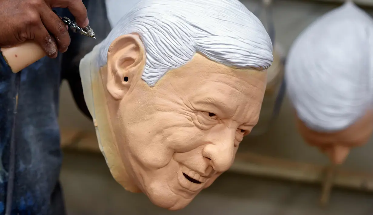 Pekerja memberikan sentuhan akhir pada topeng lateks dari calon presiden Meksiko Andres Manuel Lopez Obrador, dari partai MORENA, di Rev, sebuah pabrik di Cuernavaca, Morelos State, Meksiko, (28/3). (AFP Photo/Alfredo Estrella)