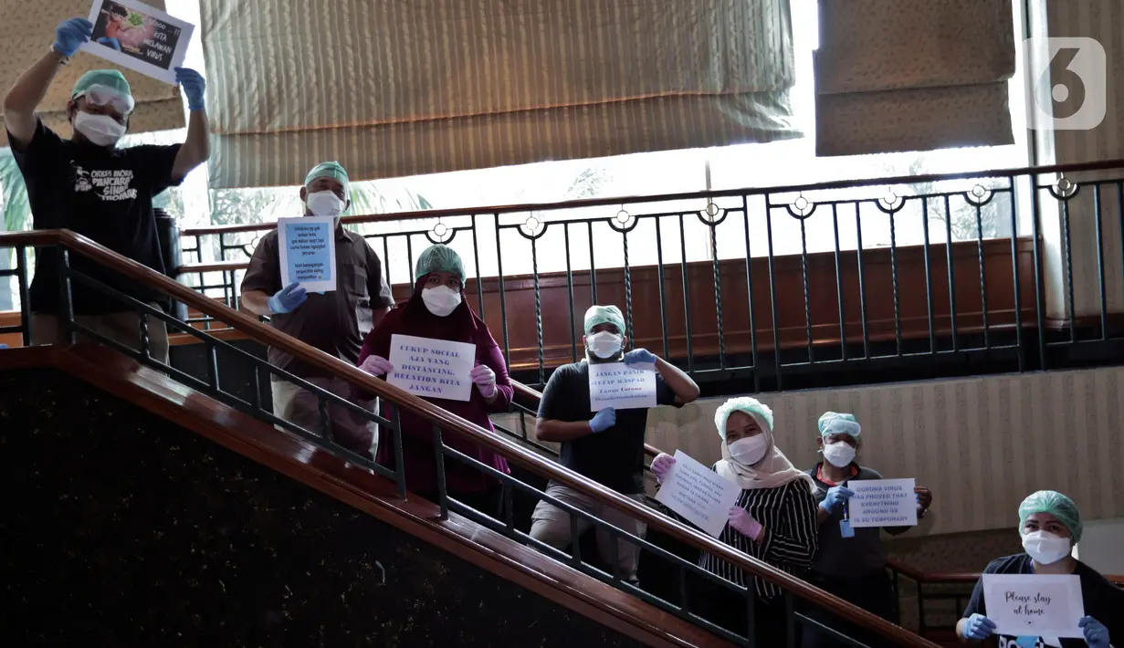 Dokter dan tenaga medis membawa tulisan berisi pesan dan tulisan untuk melawan virus corona saat sesi foto di posko tenaga medis Covid-19, Jakarta, Kamis (2/4/2020). Aksi ini mengharapkan masyarakat berdiam diri di rumah, untuk ikut bergerak memutus mata rantai covid-19. (Liputan6.com/Johan Tallo)