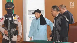Terdakwa terorisme, Aman Abdurrahman dengan pengawalan ketat memasuki ruang sidang vonis di PN Jakarta Selatan, Jumat (22/6). Dalam perkara ini, Aman dituntut hukuman mati karena menggerakkan aksi teror bom di Indonesia. (Liputan6.com/Angga Yuniar)