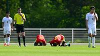 Sujud syukur dua pemain Guinea U-23 merayakan kemenangan 1-0 atas Timnas Indonesia U-23 tak lama setelah wasit Francois Letexier meniup peluit akhir laga play-off antar-konfederasi menuju Olimpiade Paris 2024 di Stade Pierre Pibarot, Centre National du Football de Clairefontaine, Prancis, Kamis (9/5/2024). (AFP/Miguel Medina)