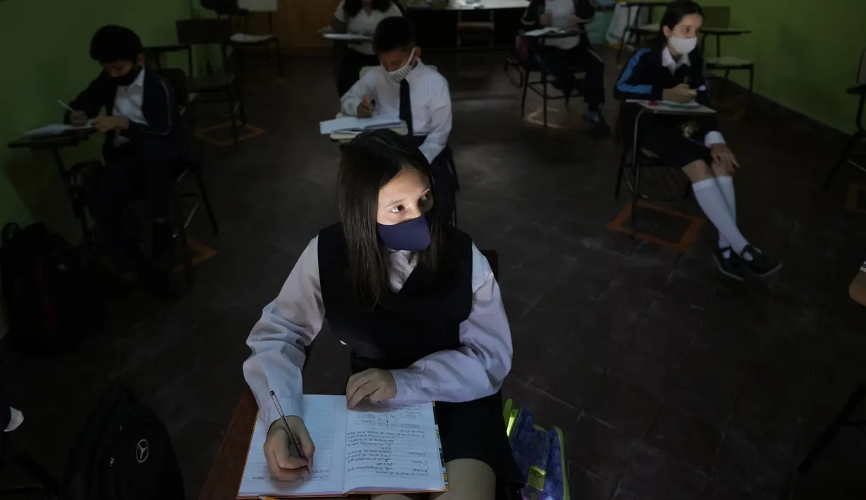 Murid kelas enam Dana Almada menghadiri hari pertama sekolah tatap muka di National School Two Celsa Speratti School, Asuncion, Paraguay, Senin (30/8/2021). Sekolah tatap muka digelar setelah satu setengah tahun belajar jarak jauh di tengah pandemi COVID-19. (AP Photo/Jorge Saenz)