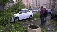Sebuah mobil tertimpa pohon yang tumbang setelah badai 110 km/jam menerjang Moskow (29/5/2017) (AP)