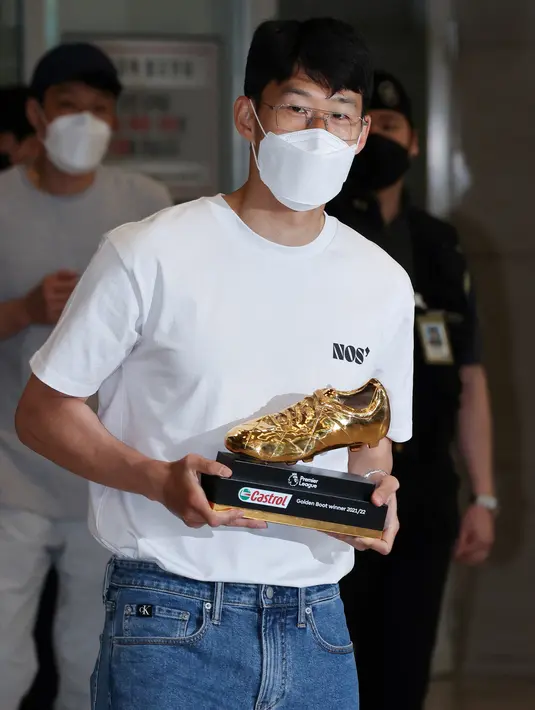 Penyerang Tottenham Hotspur asal Korea Selatan Son Heung-min memegang trofi Sepatu Emas Liga Inggris setibanya di Bandara Internasional Incheon (24/5/2022). Pada musim 2021-2022, Son Heung-min tercatat mampu mengoleksi total 23 gol dari 35 penampilan bersama Tottenham Hotspur di Liga Inggris. (AFP/Yonhap)