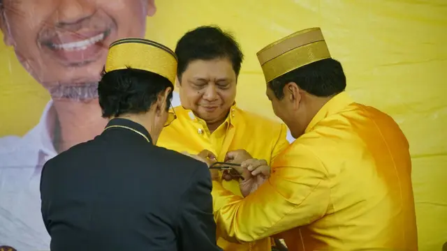Pemasangan baju adat pada Ketua umumGolkar Airlangga Hartarto mendampingi Nurdin Halid mendaftar di KPU (Liputan6.com/Fauzan)