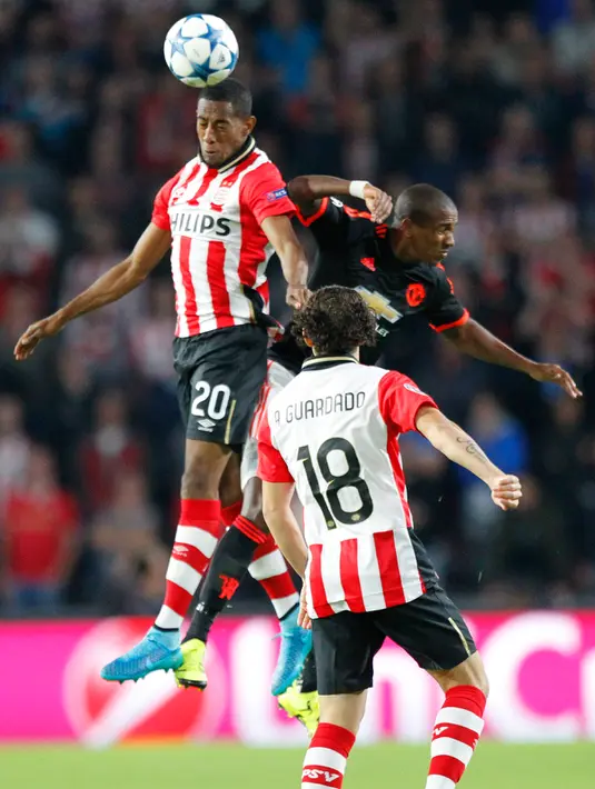 Bek PSV, Joshua Brenet (kiri) berebut bola udara dengan gelandang MU, Ashley Young pada laga penyisihan grup B Liga Champions di Stadion Philips, Belanda (16/9/2015). PSV menang atas MU dengan skor 2-1. (Reuters/Michael Kooren)