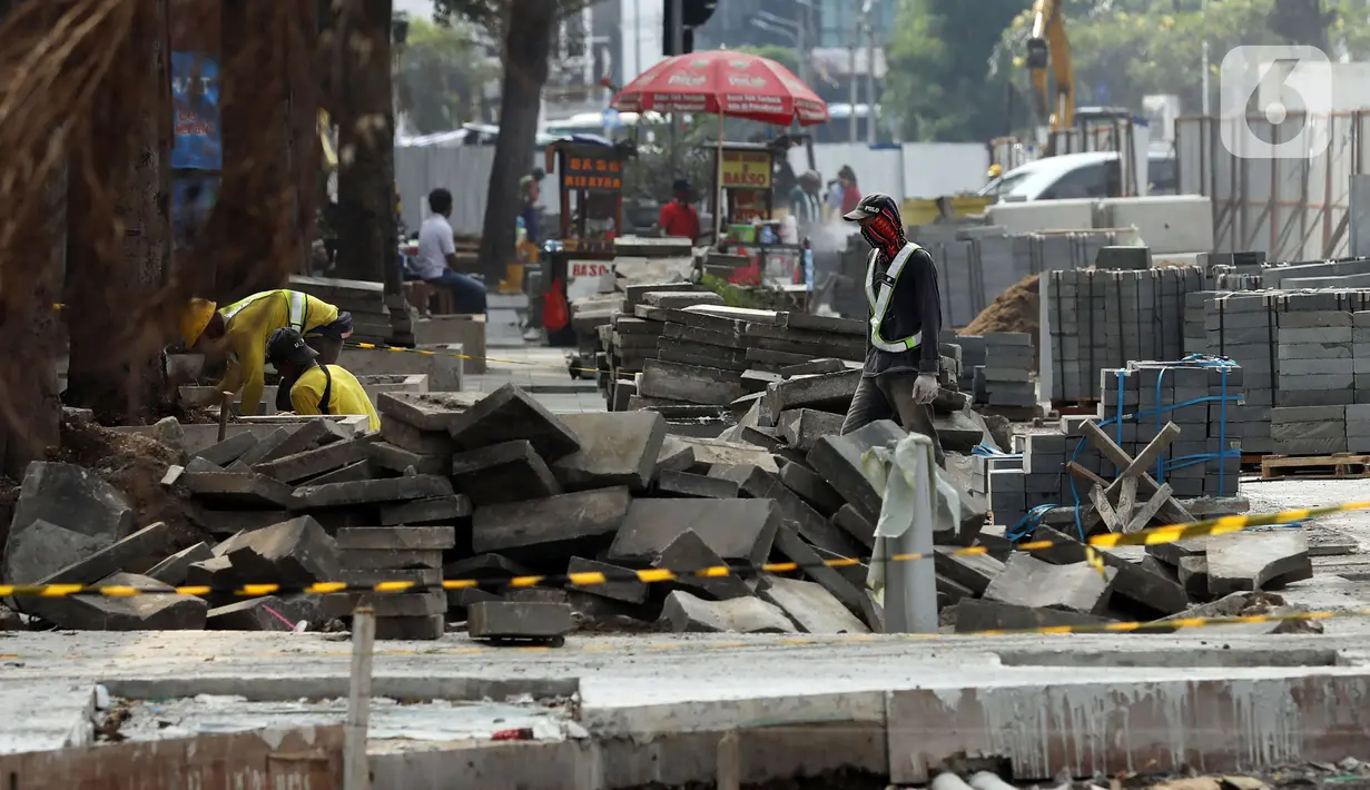 Pekerja mengerjakan proyek rivitalisasi jalan di kawasan Kota Tua, Jakarta Barat, Senin (17/5/2022). Dinas Bina Marga DKI Jakarta terus mengejar target penyelesaian revitalisasi trotoar di kawasan Kota Tua yang ditargetkan bulan Juli 2022 diharapakn selesai. (Liputan6.com/Johan Tallo)