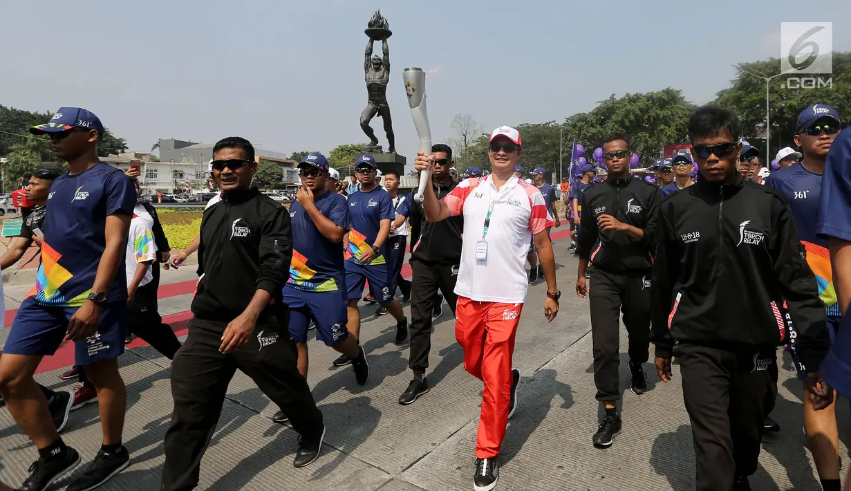 Presiden Direktur Combiphar, Michael Wanandi saat Torch Relay Asian Games 2018 di Jalan Jendral Sudirman, Sabtu (18/8). Hari terakhir kirab obor Asian Games ini api abadi dibawa dari Tugu Monas hingga Gelora Bung Karno. (Liputan6.com/ Fery Pradolo)