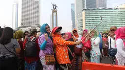 Emak-emak dari masyarakat pencinta kebaya dan sarung Indonesia berselfie saat mengikuti parade di Bundaran HI, Jakarta, Minggu (28/7/2019). Parade tersebut bertujuan untuk mengajak masyarakat agar mencintai busana tradisional khas Indonesia. (Liputan6.com/Angga Yuniar)