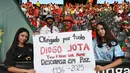 Berbagai media Spanyol menyebutkan bahwa penyerang Liverpool Diogo Jota meninggal dunia pada Kamis (3/7/2025) siang WIB. Tampak dalam foto, para penggemar memegang tulisan saat mereka memberikan penghormatan kepada penyerang Liverpool asal Portugal, Diogo Jota, menjelang pertandingan sepak bola UEFA Women's Euro 2025 Grup B antara Spanyol dan Portugal di stadion Wankdorf di Bern, Jerman pada 3 Juli 2025. (Miguel MEDINA/AFP)