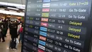 Penumpang berjalan melewati papan informasi yang menampilkan penerbangan tertunda di Bandara Gimpo, Seoul, pada Kamis 13 November 2025, pada hari ujian masuk perguruan tinggi tahunan yang dikenal secara lokal sebagai Suneung. (Jung Yeon-je/AFP)