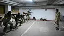 Tentara Pasukan Pertahanan Teritorial Ukraina, cadangan militer Angkatan Bersenjata Ukraina, mengambil bagian dalam pelatihan militer di garasi bawah tanah yang telah diubah menjadi pangkalan pelatihan dan logistik di Kiev, pada Jumat (11/3/2022). (Sergei SUPINSKY / AFP)