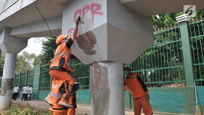 Petugas PPSU membersihkan coretan yang mengotori tembok di kawasan Gedung DPR, Jakarta, Rabu (25/9/2019). Demonstrasi mahasiswa yang berujung ricuh yang berujung kerusuhan tersebut menyebabkan fasilitas umum rusak dan penuh coretan yang dibuat oleh pendemo. (merdeka.com/Iqbal S Nugroho)