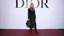 Elle Macpherson hadir dengan mengenakan koleksi dari Dior Cruise 2022, printed grey wool and cashmere coat, dipadu dengan dress katun berwarna hitam. Foto: Document/Dior.