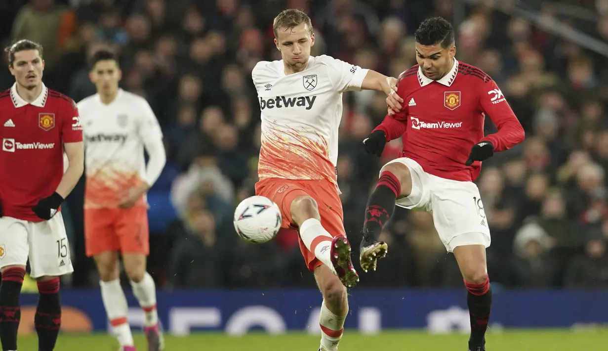 Gelandang Manchester United atau MU Casemiro berebut bola dengan gelandang West Ham United Tomas Soucek pada putaran kelima Piala FA di Old Trafford, Kamis (2/3/2023) dinihari WIB. Duel Man United vs West Ham  tuntas dengan skor 3-1. (AP Photo/Dave Thompson)