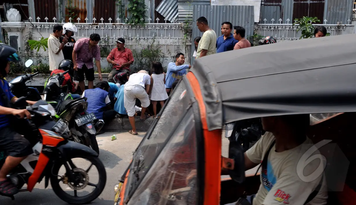 Kerumunan warga yang sedang mencari batu giok di trotoar  Kawasan Tomang sempat membuat lalu lintas menjadi tersendat, Jakarta, Sabtu, (9/5/2015). (Liputan6.com/Andrian M Tunay)