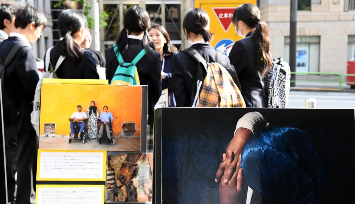 Anggota dari Amnesty International menjelaskan tentang situasi perang saudara yang melanda Aleppo, Suriah kepada para siswa di kampus Universitas Meiji di Tokyo, Jepang (18/11). (AFP/Toshifumi Kitamura)