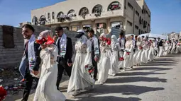 Puluhan pasangan pengantin Palestina mengikuti pernikahan massal yang digelar di kota Gaza, 11 Mei 2026. Tampak dalam foto, para pengantin Palestina berkumpul selama perayaan pernikahan massal untuk para pengantin Palestina yang diselenggarakan oleh Yayasan Bantuan Kemanusiaan Turki (IHH) di Kota Gaza pada 11 Mei 2026. (Omar AL-QATTAA/AFP)