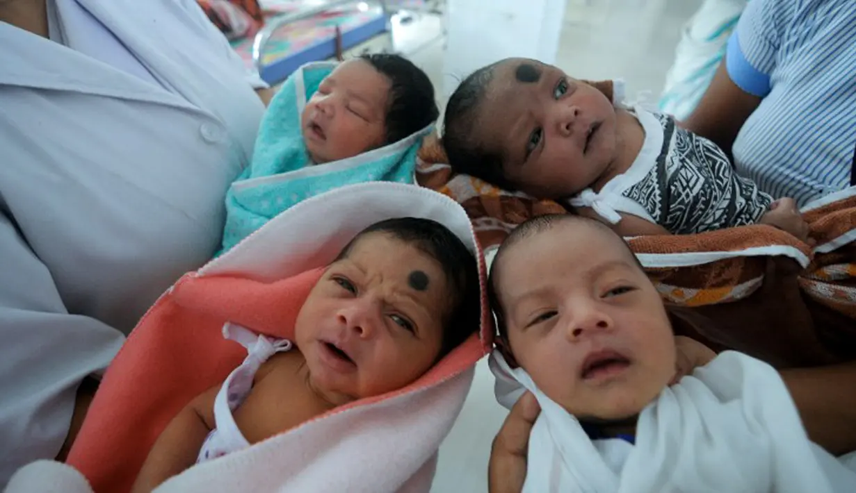 Perawat menggendong bayi yang baru lahir di bangsal anak di rumah sakit Guwahati 10 Juli 2014. Sebuah penelitian baru dari PBB memprediksi bahwa India akan melampaui China sebagai negara dengan penduduk terbanyak pada tahun 2022.(AFP Photo/Biju BORO)