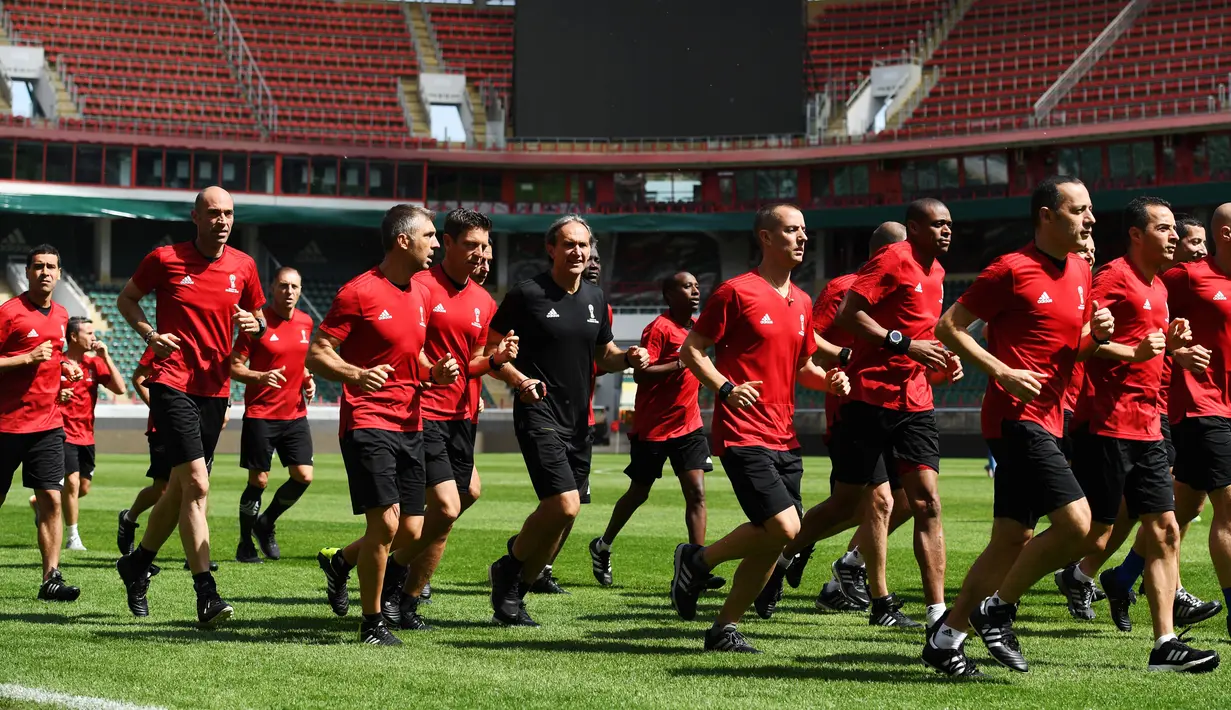 Para wasit  melakukan pemanasan saat menjalani sesi latihan di Moskow, Rusia, Selasa (11/6). Persiapan dilakukan para wasit untuk menjaga kebugaran saat pertandingan turnamen Piala Dunia 2018 Rusia. (AFP Photo/Kirill Kudryavtsev)