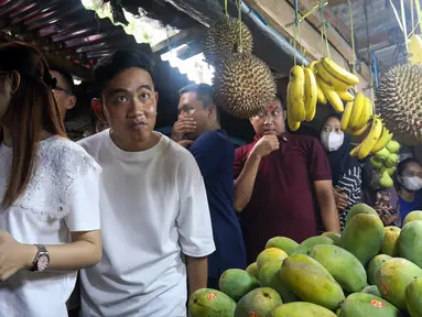 Calon wakil presiden nomor urut 2 Gibran Rakabuming Raka (kedua kiri) didampingi sang istri Selvi Ananda (kiri) blusukan ke Pasar Rawasari, Jakarta, Minggu (3/11/2023). Gibran blusukan sambil membagikan susu dan berbelanja di Pasar Rawasari. (Liputan6.com/Herman Zakharia)