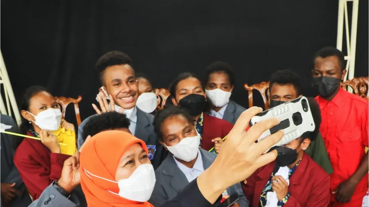 Gubernur Jawa Timur Khofifah Indar Parawansah selfie bersama siswa asal Papua di Jember (Dian Kurniawan/Liputan6.com)