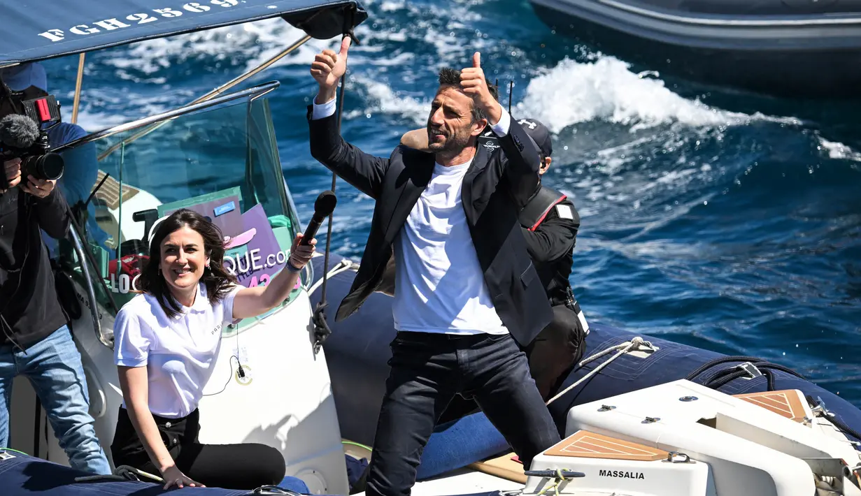 Presiden Komite Penyelenggara Olimpiade dan Paralimpiade Paris 2024, Tony Estanguet menyapa kapal barque Belem dari abad ke-19 Prancis yang berlayar di dekat pantai Marseille, di Laut Mediterania, pada 8 Mei 2024. (NICOLAS TUCAT/AFP)