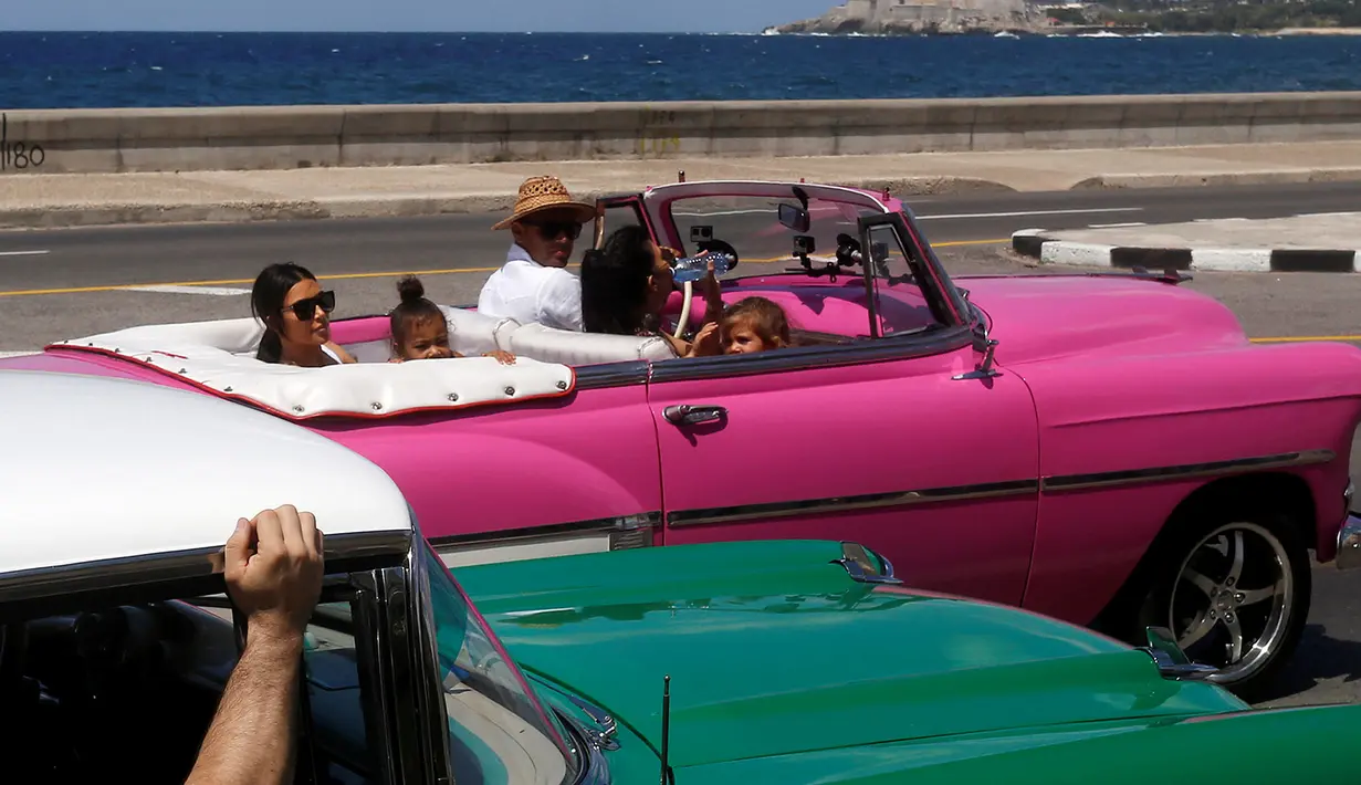 Kim Kardashian dan putrinya berada duduk dibelakang mobil kuno di Malecon, Havana, Cuba, 5 Mei 2016. Kim bersama seluruh anggota keluarganya ke Kuba untuk syuting serial reality show miliknya. (REUTERS / Stringer)