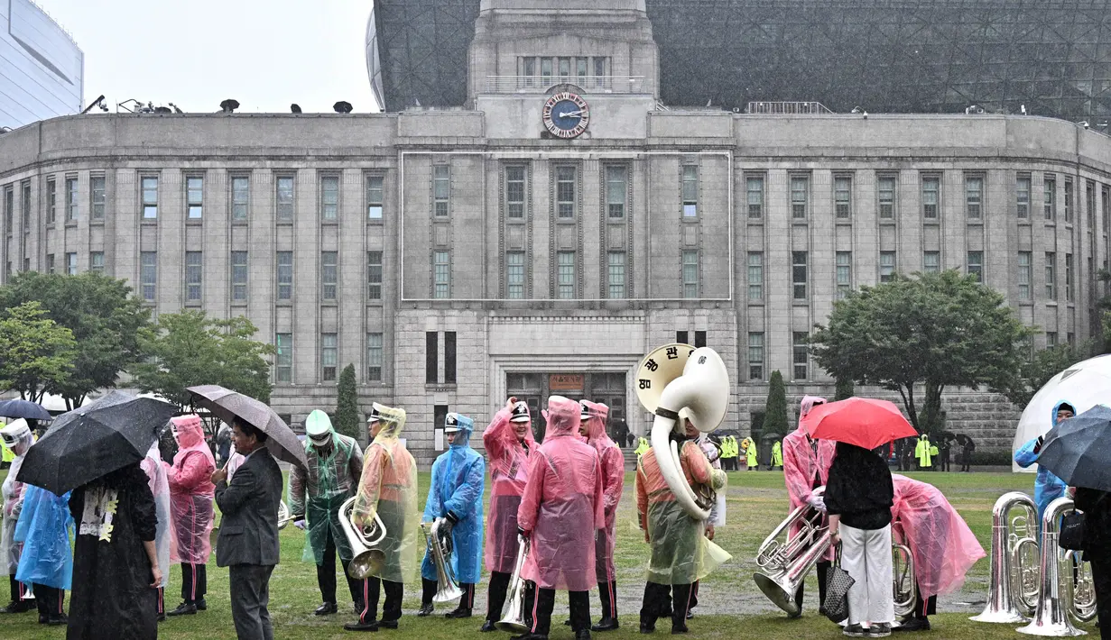 Anggota marching band menunggu di tengah hujan sebelum parade militer untuk merayakan Hari Angkatan Bersenjata ke-75 di Seoul pada tanggal 26 September 2023. (Anthony WALLACE/AFP)