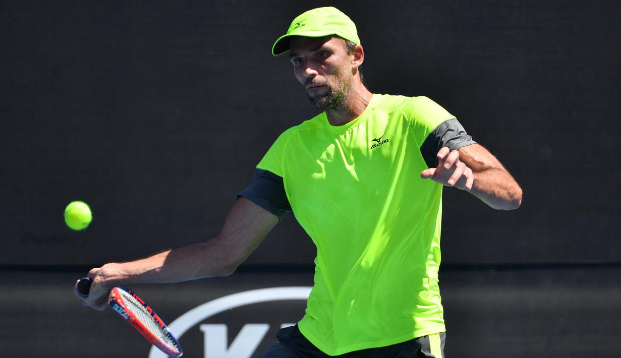 Petenis Kroasia, Ivo Karlovic mengembalikan bola dari petenis Jepang, Yuichi Sugita di babak kedua Australia Terbuka 2018, Rabu (17/1). Durasi pertandingan Karlovic dan Yuichi menjadi rekor terpanjang di turnamen ini, 4 jam dan 33 menit. (SAEED KHAN/AFP)