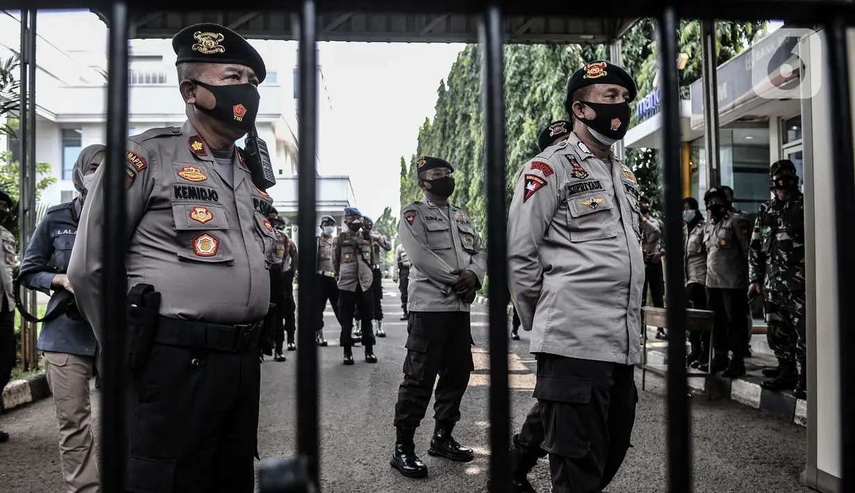 Penjagaan ketat di pintu masuk Pengadilan Negeri Jakarta Timur saat sidang perdana Rizieq Shihab, Jakarta, Selasa (16/3/2021). Meski sidang digelar secara virtual, polisi tetap menjaga ketat PN Jakarta Timur guna mencegah kerumunan massa. (merdeka.com/Iqbal S. Nugroho)