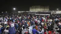 Ratusan buruh migran menunggu di terminal bus untuk berangkat ke desa mereka, New Delhi, India, Senin (19/4/2021). Pihak berwenang mengatakan pada hari Senin bahwa rumah sakit telah didorong hingga batasnya. (AP Photo)
