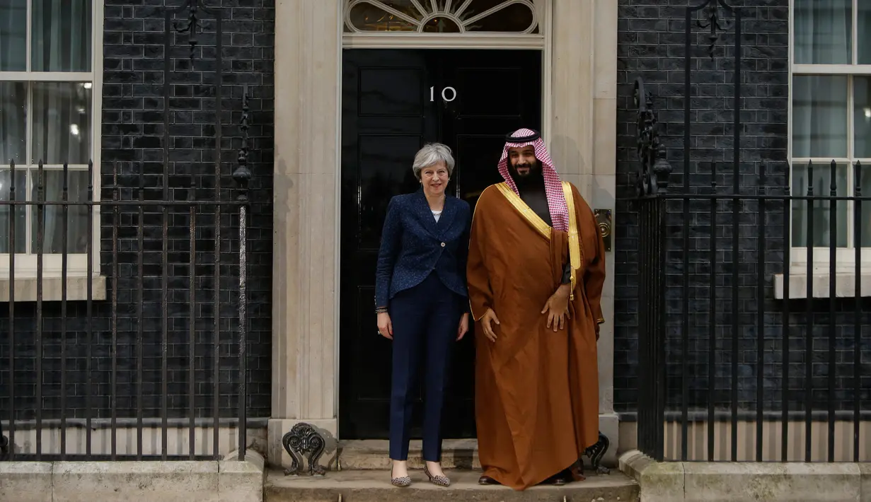 PM Inggris Theresa May dan Putra Mahkota Arab Saudi, Pangeran Mohammed bin Salman menemui awak media saat menyambut kunjungannya di 10 Downing Street, London, Rabu (7/3). Putra Mahkota Saudi memulai kunjungan resmi tiga hari ke Inggris (AP/Alastair Grant)
